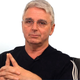 John Riccitiello clasps his hands together in regret.